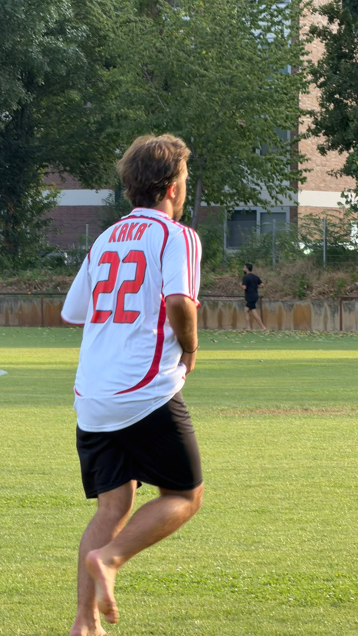 Ein Spieler läuft barfuß über den Rasen